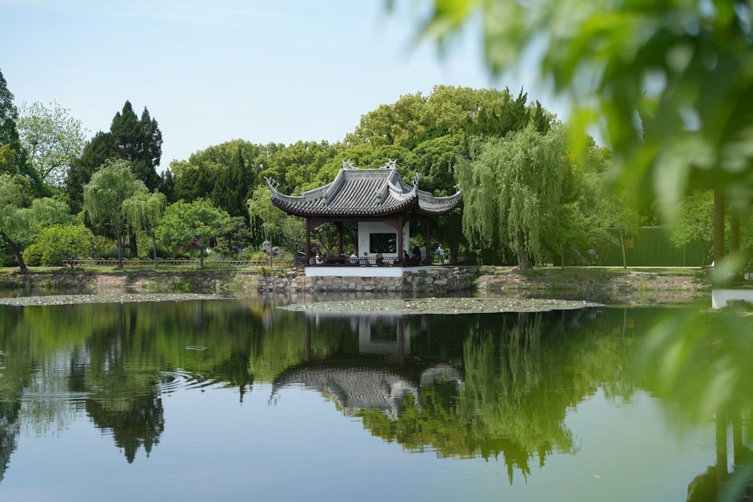 Traditional Chinese garden pavilion reflected in a calm lake