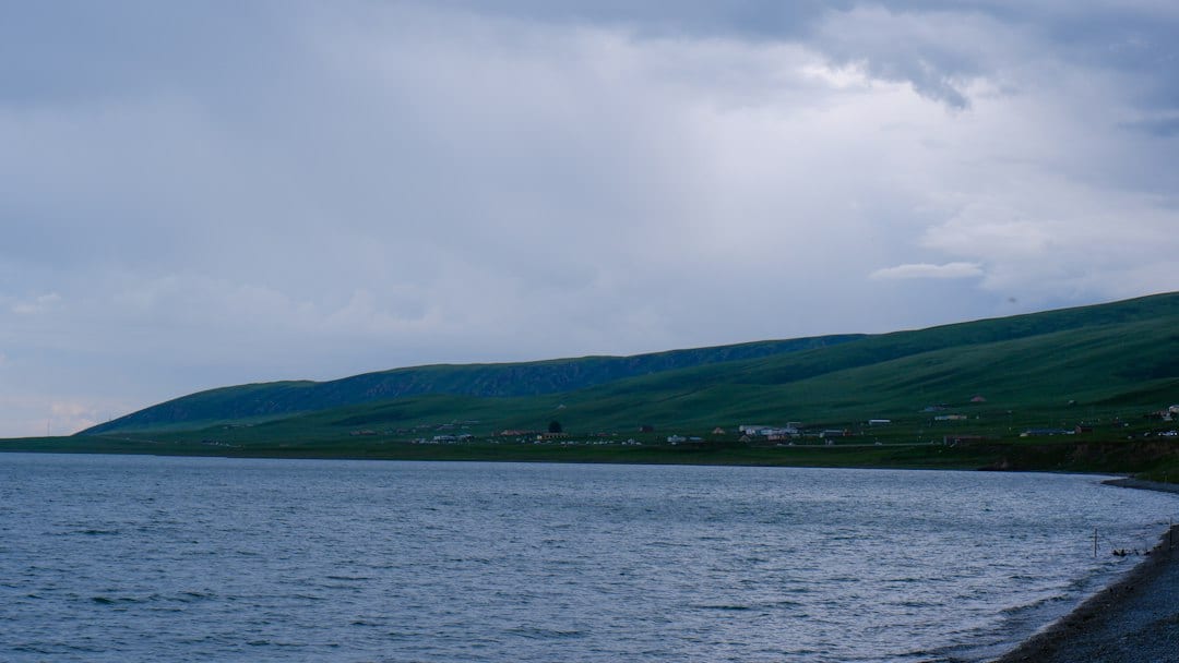 Qinghai Lake with calm blue water and green hills