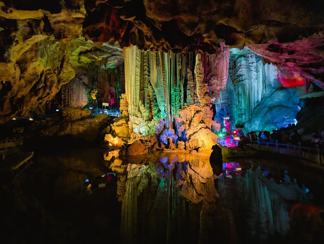 Colorfully lit stalactites inside Reed Flute Cave