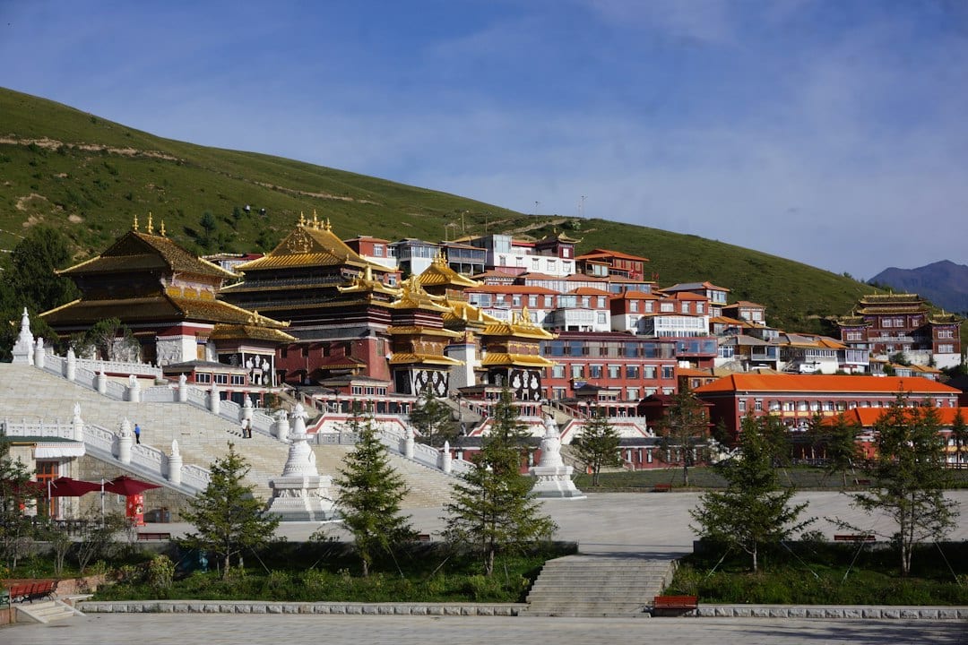 Labrang Monastery with golden roofs and red walls on a grassy hillside