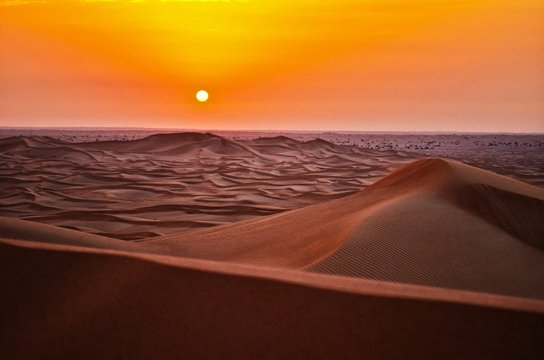 Golden sand dunes in Xinjiang desert at sunset
